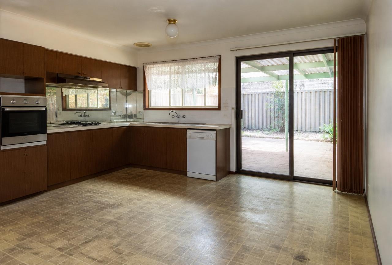 Küche mit dunklen Holzfronten und altem Vinylboden vor der Renovierung